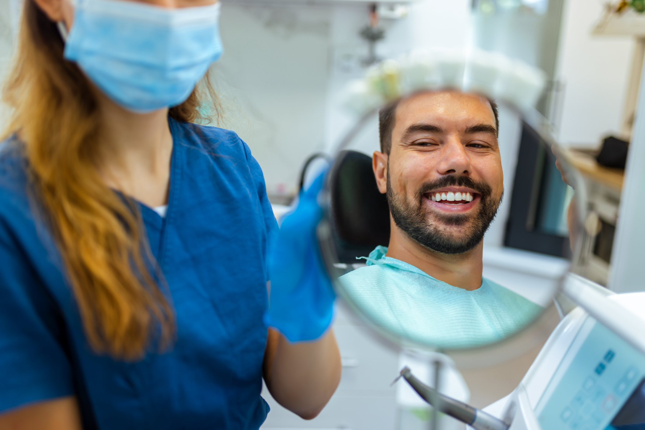 patient looking at his smile in the dental mirror